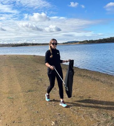 Volunteer cleaning the shore of Lake Orellana